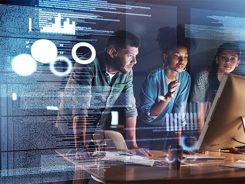 A group of people reviewing charts and graphs on a screen.