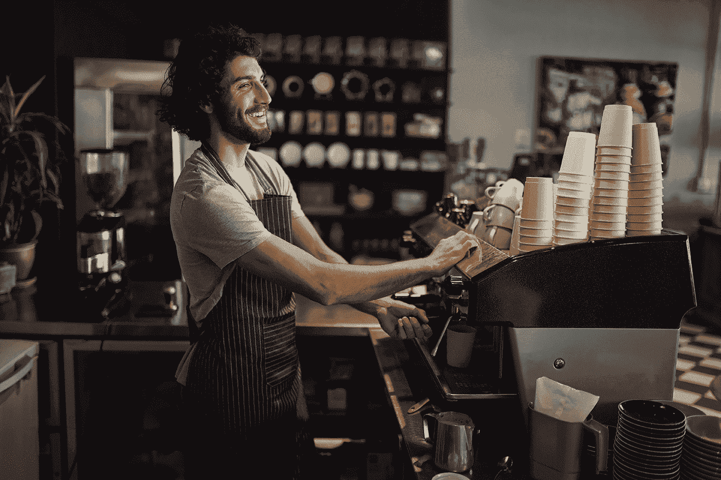 A happy barista making a coffee in a neat coffee shop-min[1]-min