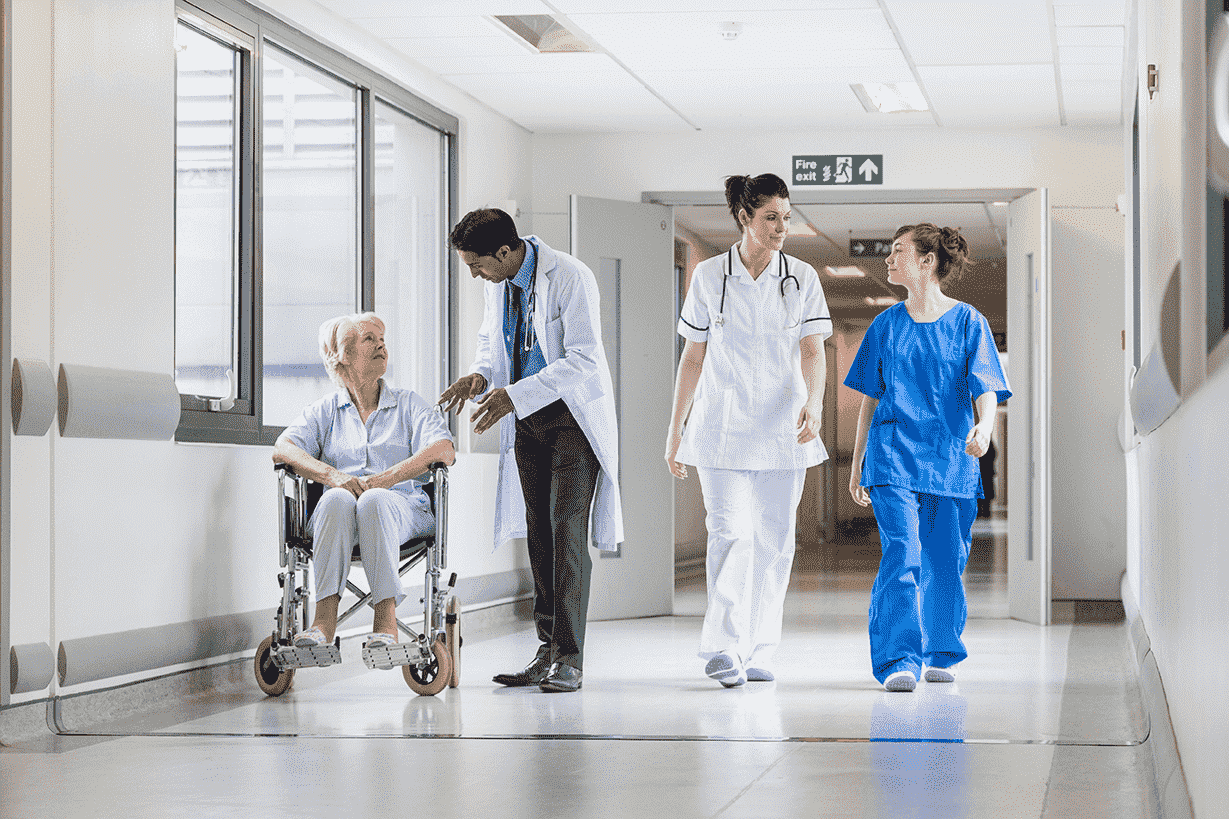 Two doctors, a nurse and a patient in a hospital corridor[1]-min